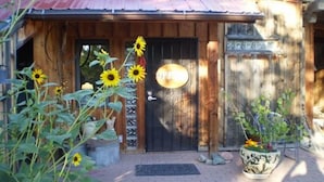 Un bâtiment rustique en bois, doté d’un toit en métal, d’une porte noire et d’une enseigne indiquant « Boîte postale ».