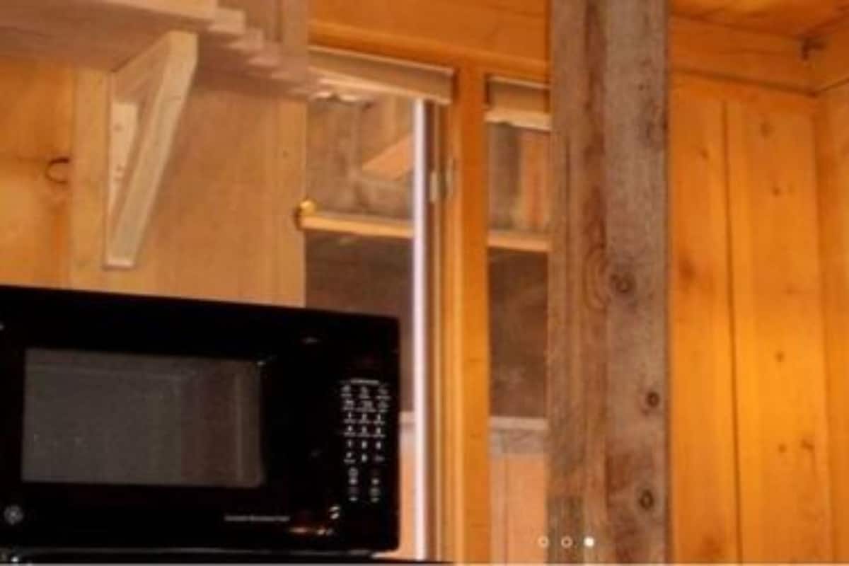 A wooden interior with a microwave on the left.
