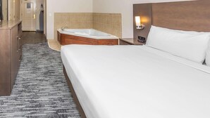 A hotel room with a large bed, a separate bathroom with a bathtub, a small desk, and a nightstand. - Country Inn & Suites by Radisson, Smyrna - Atlanta Northwest (Smyrna)