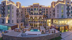 A multi-story hotel with a central courtyard, outdoor pool, and multiple balconies. - Hotel Boulevard, Autograph Collection (Dubai)