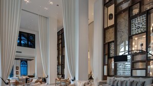 A spacious living area with a large sofa set, a coffee table, and a wooden accent piece. - Hotel Boulevard, Autograph Collection (Dubai)