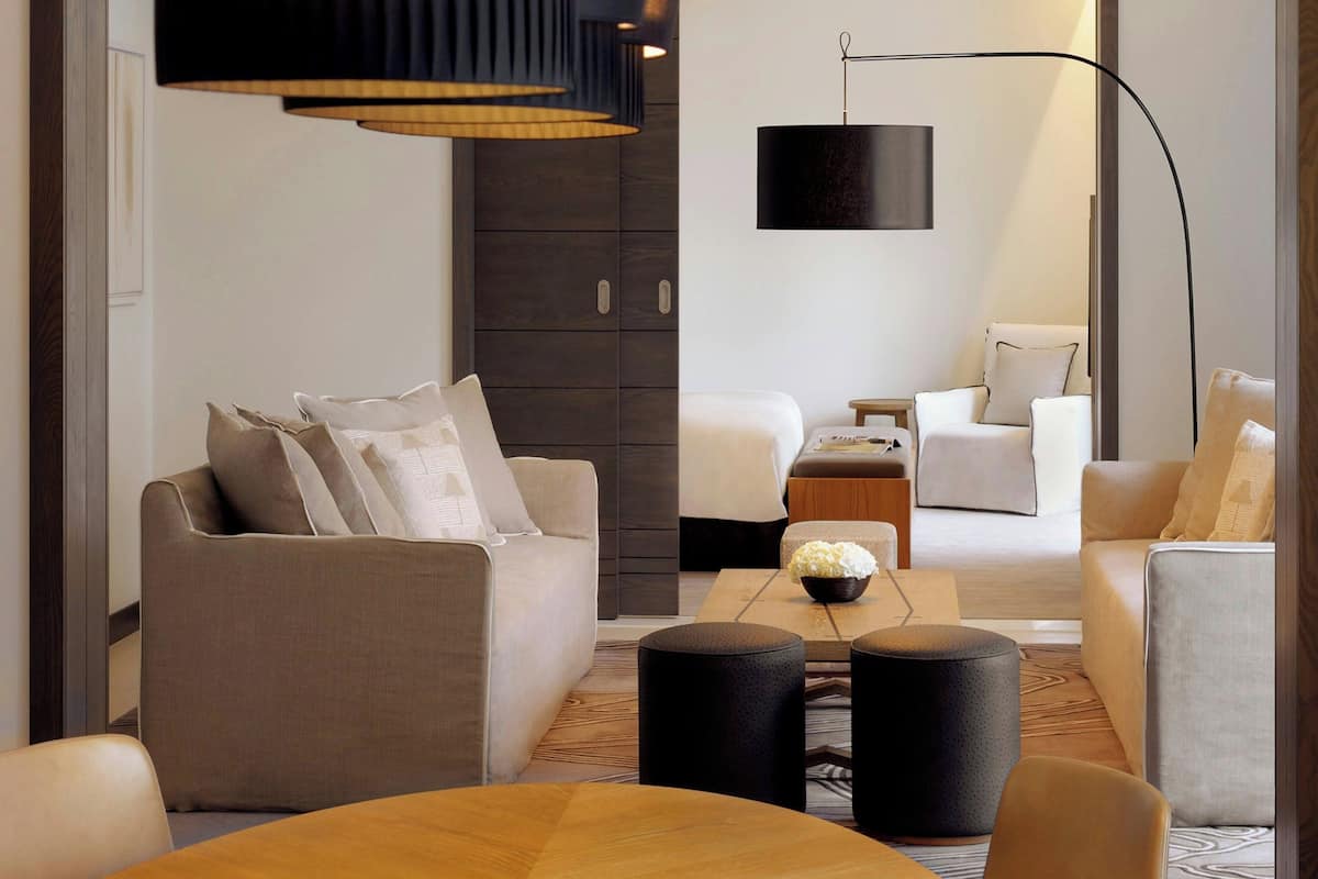 A modern living room with a sofa, armchairs, a coffee table, and a floor lamp.