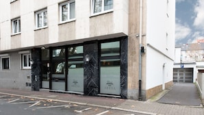 Ein Gebäude mit moderner Fassade, großen Glasfenstern und einem Schild mit der Aufschrift "ARENA".