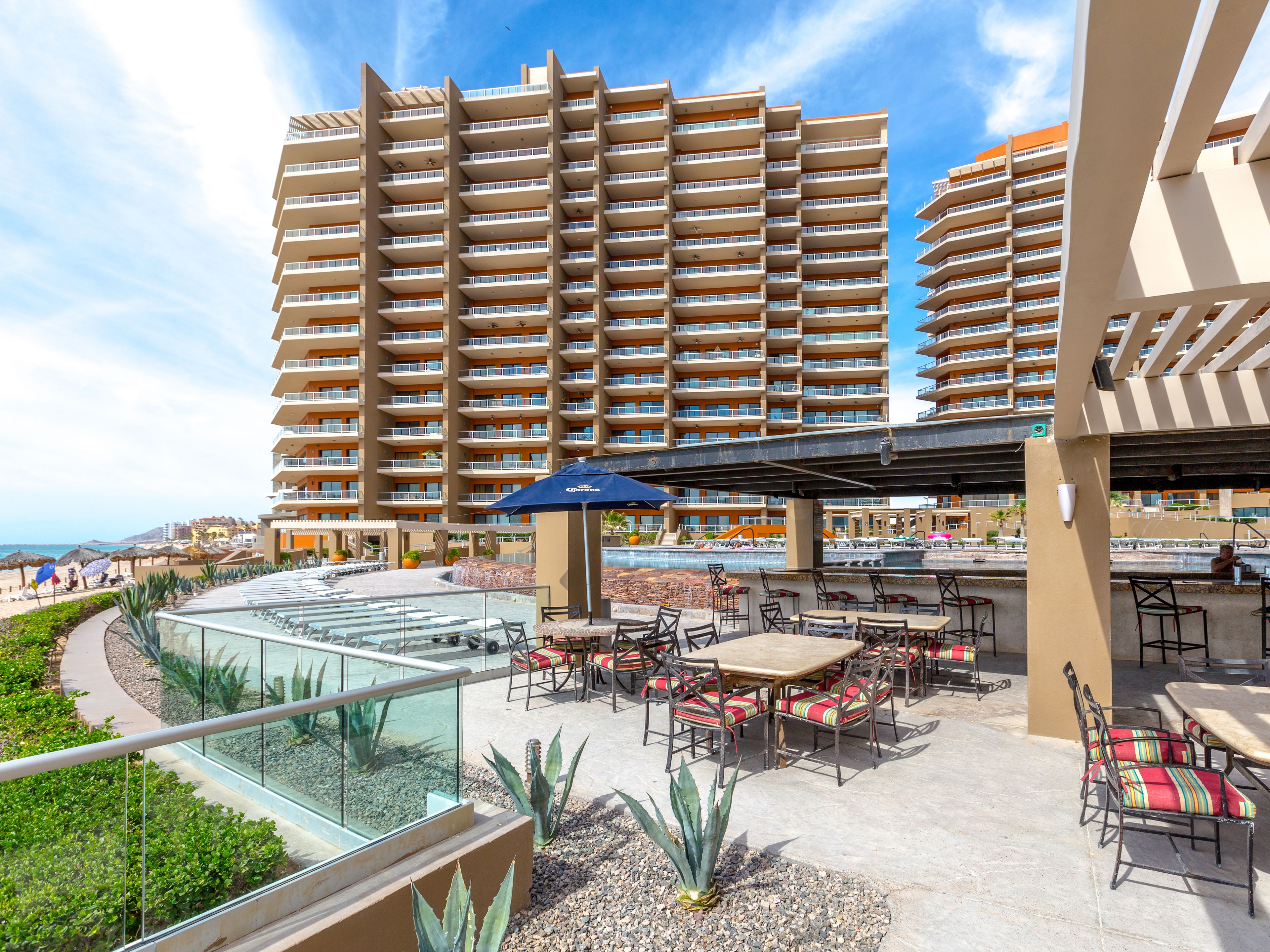 A resort with a pool area, outdoor seating, and a large building in the background.