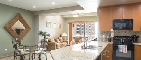 A modern kitchen with granite countertops, a built-in oven, and a microwave.