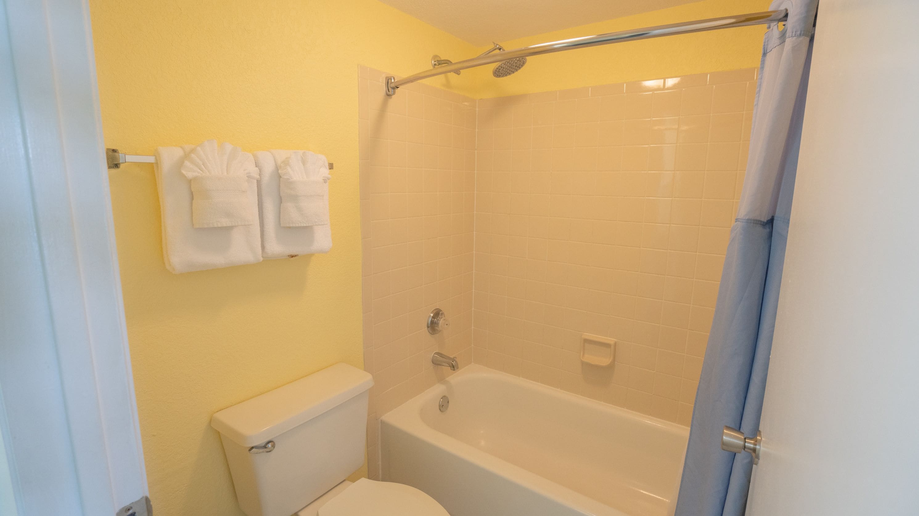 A bathroom with a toilet, bathtub, and shower.