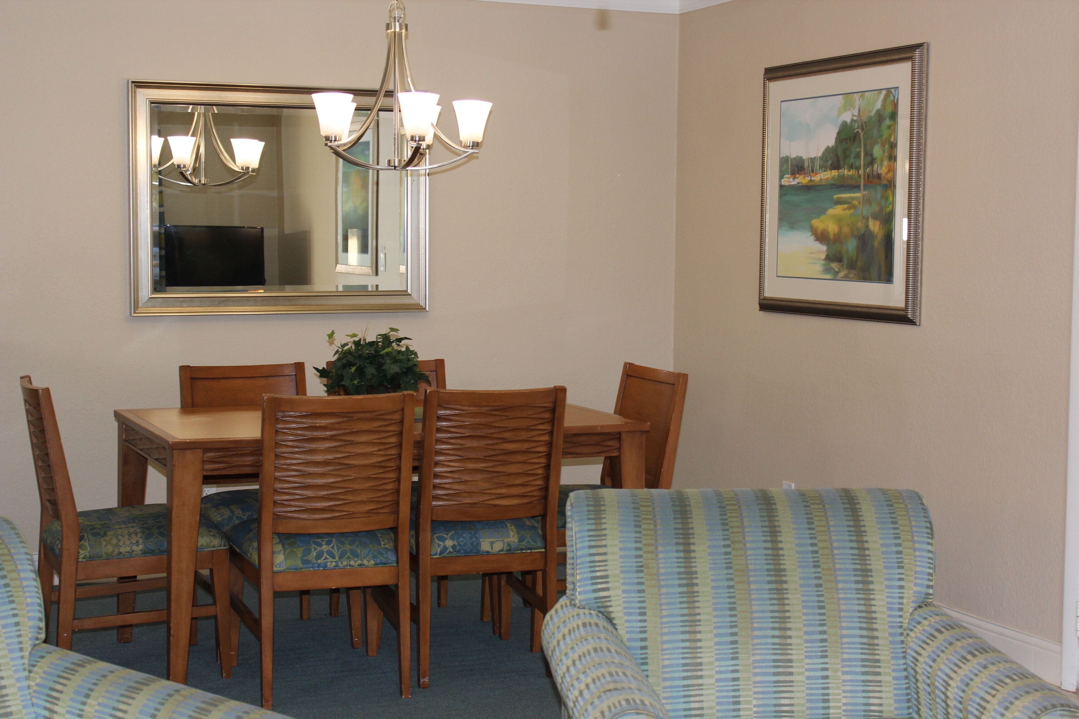 A dining area with a table, chairs, and a chandelier.