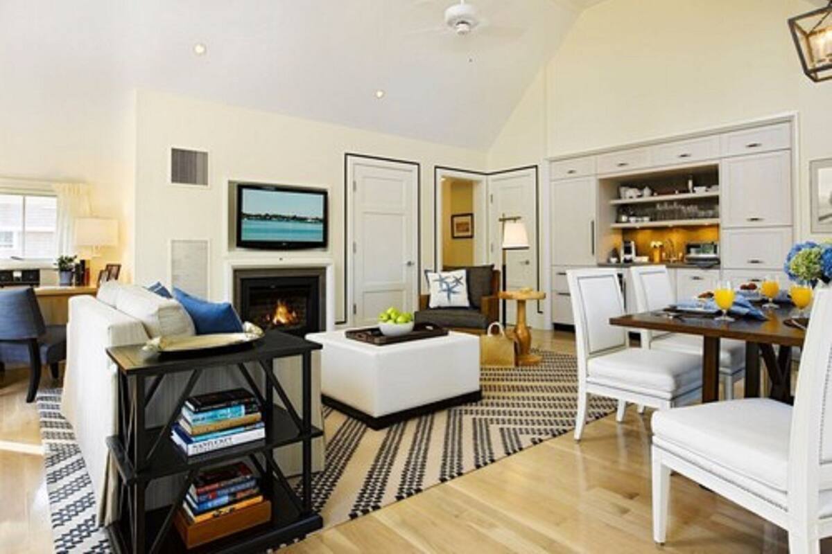 A spacious living room with a fireplace, a dining area, and a kitchen.