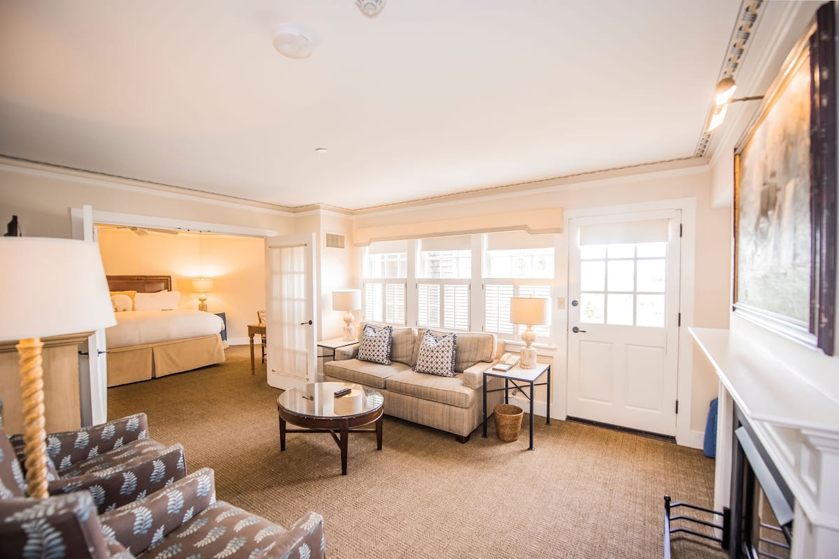 A spacious living room with a sofa set, a coffee table, and a fireplace.