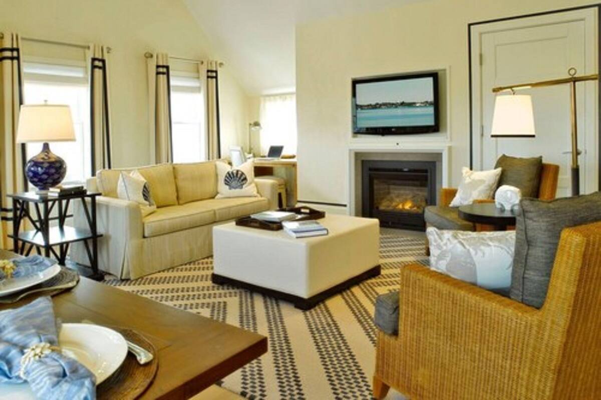 A living room with a sofa, armchair, coffee table, and fireplace.