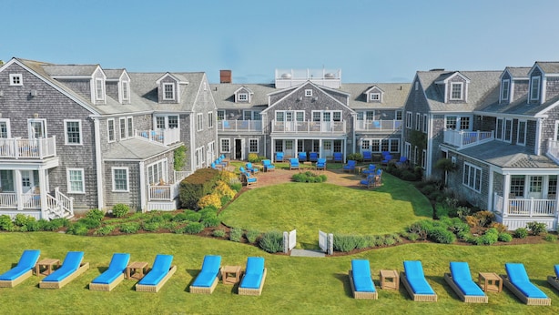 A large, multi-story building with a central courtyard, outdoor seating area, and multiple balconies. - White Elephant Hotel (Nantucket)