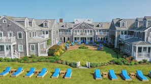 A large, multi-story building with a central courtyard, outdoor seating area, and multiple balconies. - White Elephant Hotel (Nantucket)