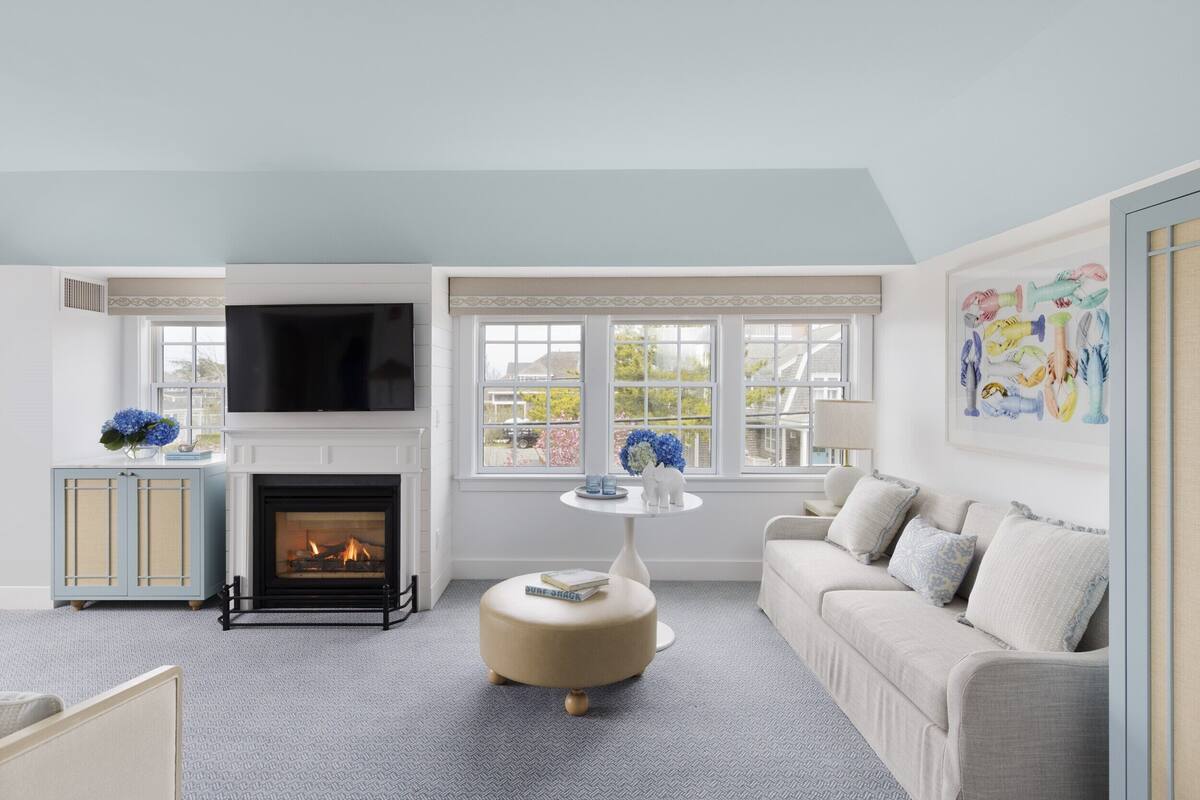 A living room with a fireplace, a sofa, a coffee table, and a TV.