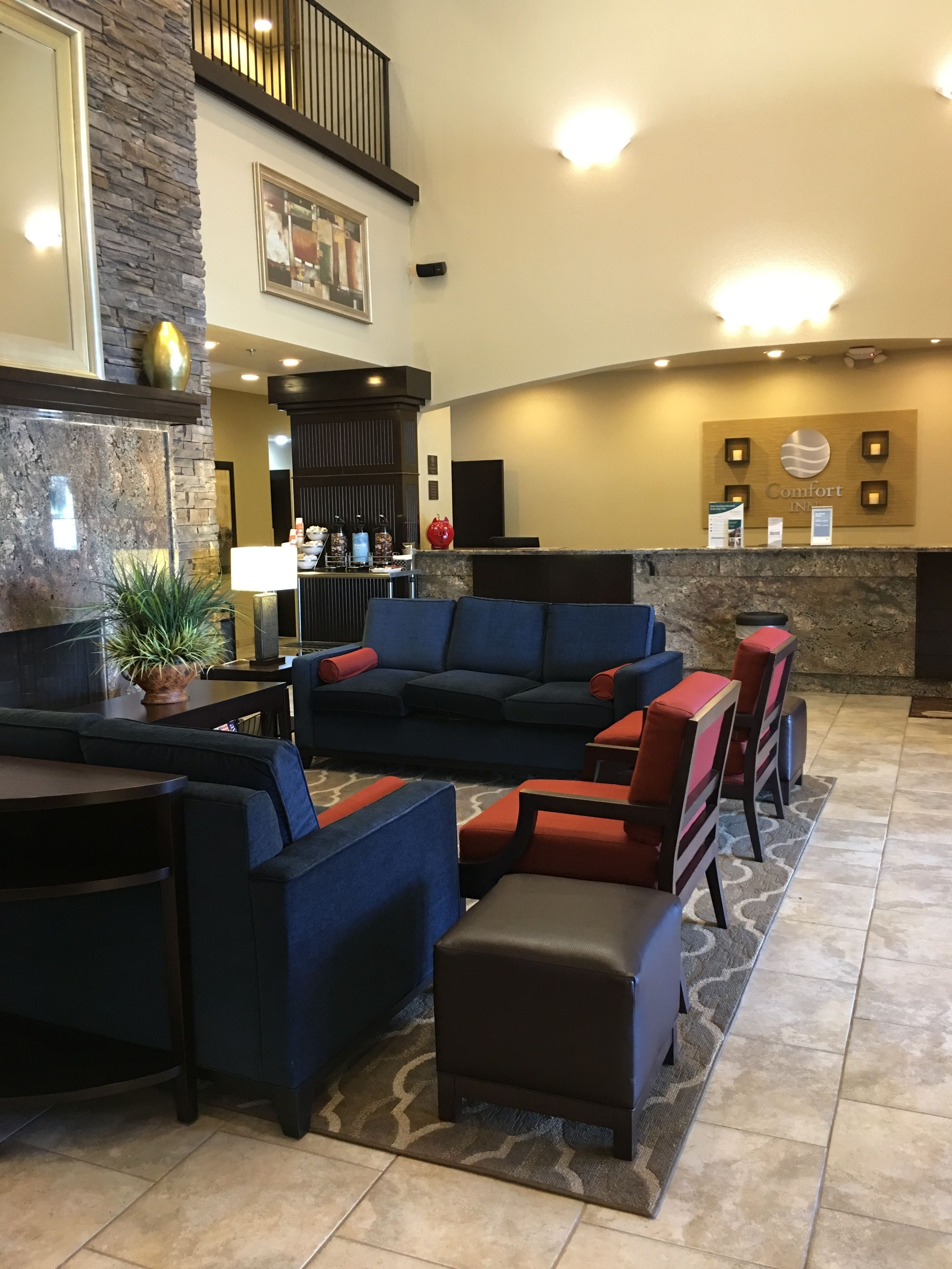 A lobby with a reception desk, seating area, and a stone accent wall.