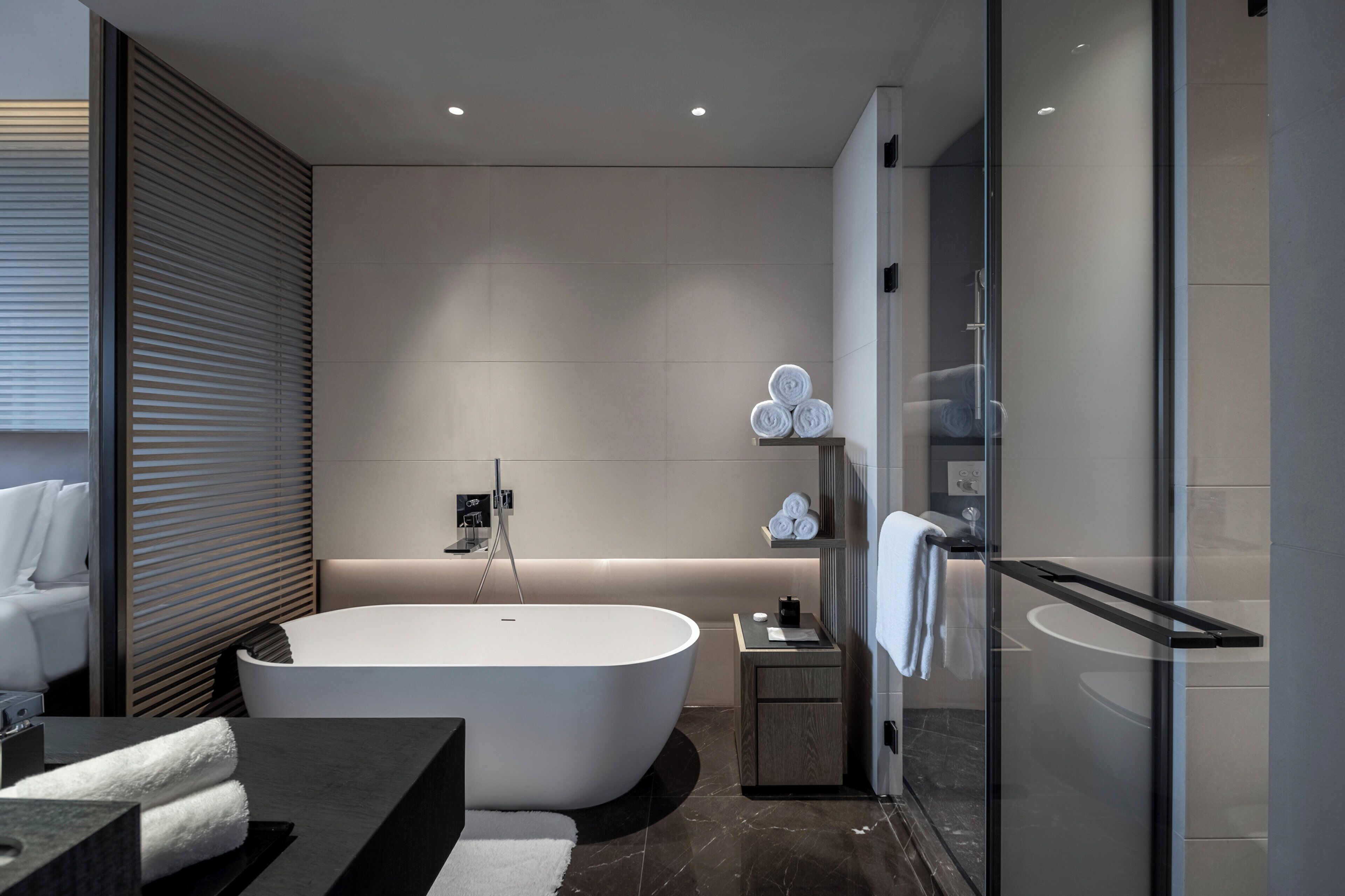 Ein modernes Badezimmer mit einer freistehenden Badewanne, einer Duschkabine aus Glas und einem minimalistischen Design.