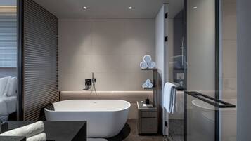 Ein modernes Badezimmer mit einer freistehenden Badewanne, einer Duschkabine aus Glas und einem minimalistischen Design.