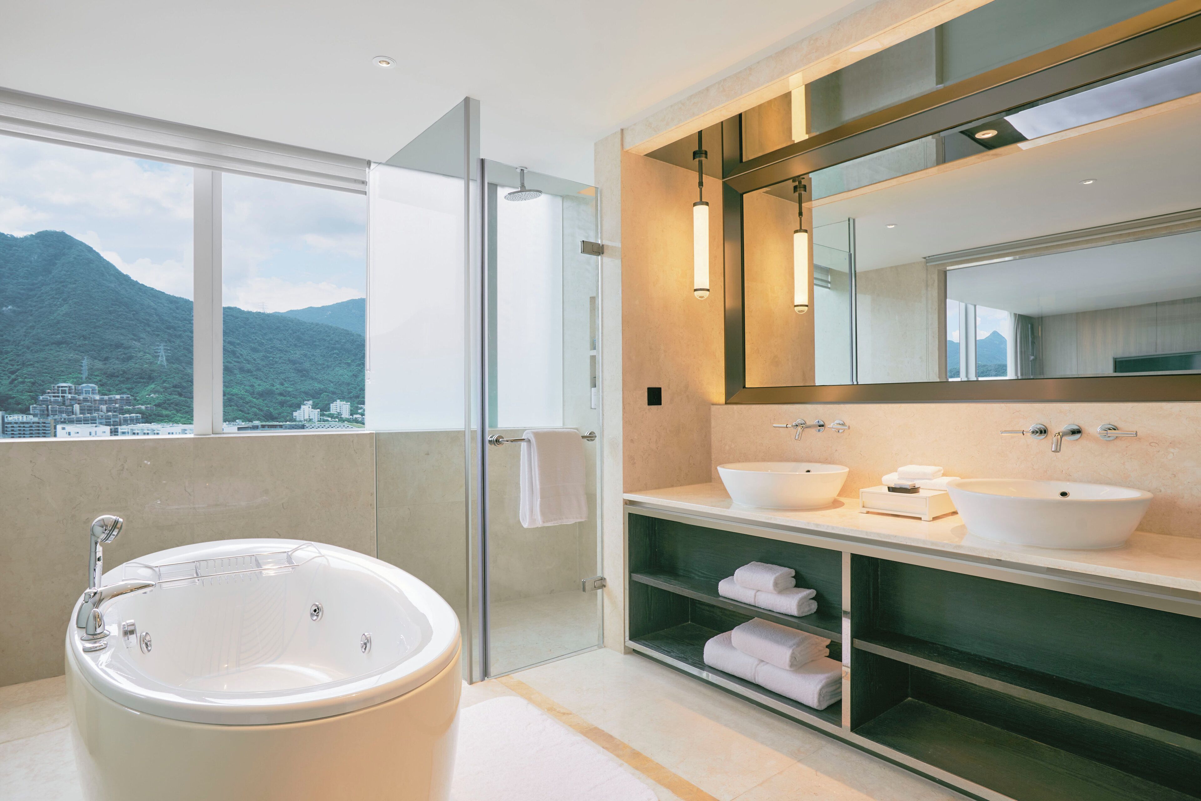 A modern bathroom with a bathtub, two sinks, and a large mirror.