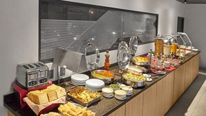 Un bufé con diversos alimentos y un tostador.