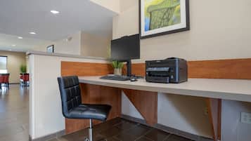 A reception desk with a computer, printer, and chair.