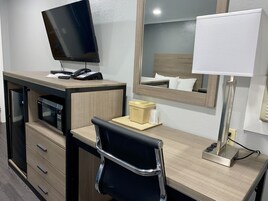 Escritorio, cortinas blackout y tabla de planchar con plancha