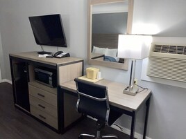 Escritorio, cortinas blackout y tabla de planchar con plancha