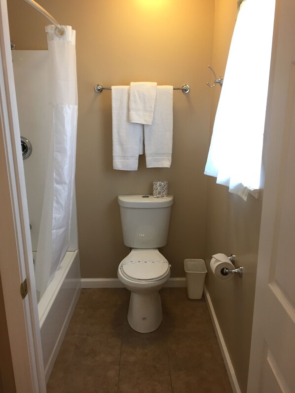 Une petite salle de bain comprenant des toilettes, une douche et un porte-serviettes.
