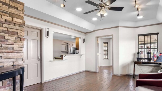 A spacious kitchen with a stone accent wall, a ceiling fan, and recessed lighting. - Rodeway Inn Waco Downtown near University (Waco)