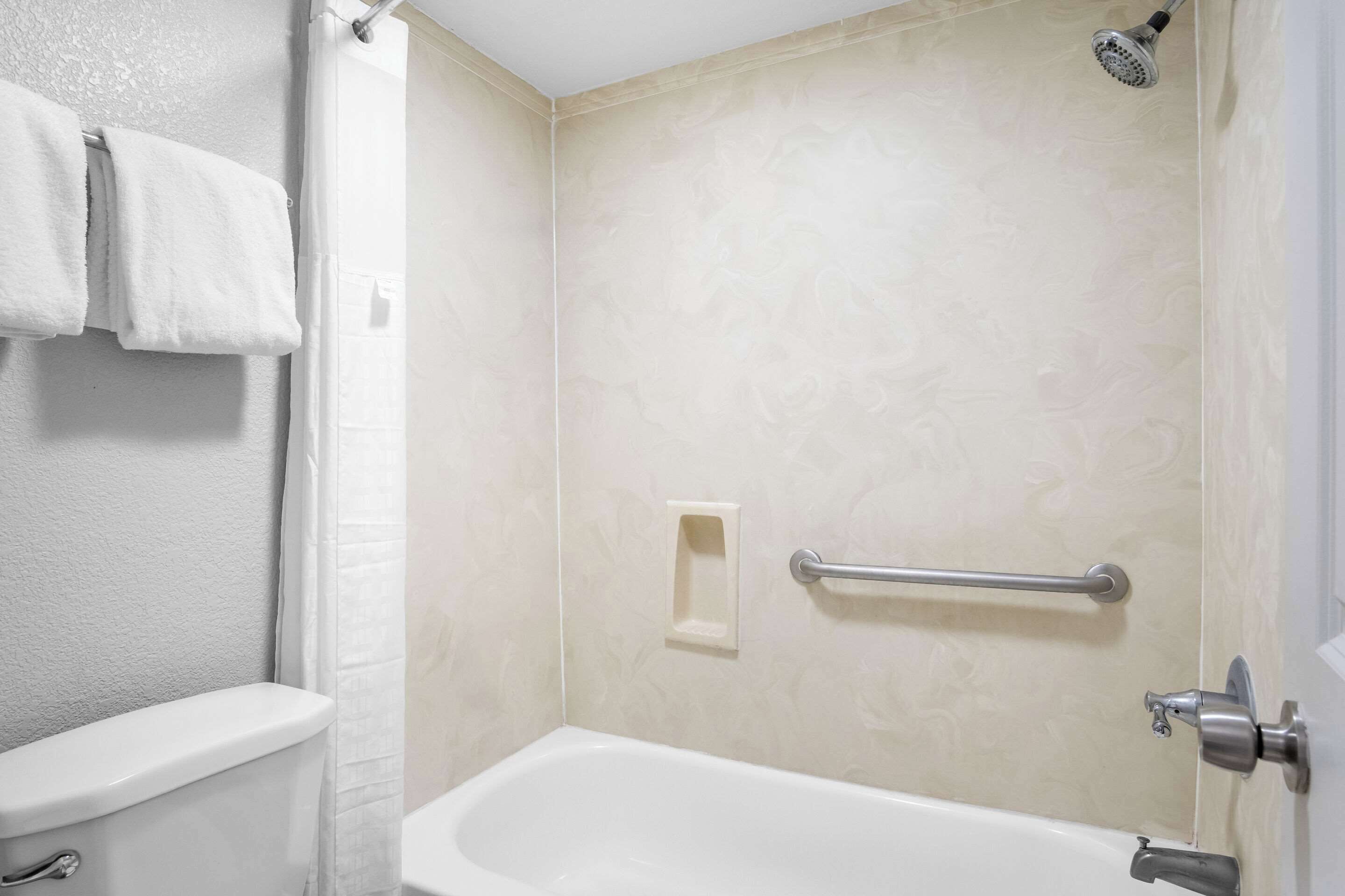 A bathroom with a toilet, a shower, and a bathtub.