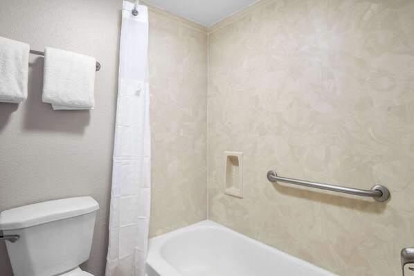 A bathroom with a toilet, a bathtub, a towel rack, and a shower curtain.