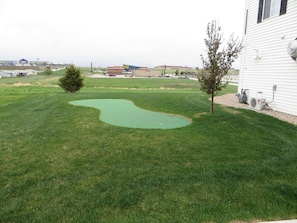 Enjoy a serene backyard with a well-maintained lawn and a small garden area.
