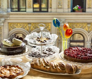 Una mesa con diversos postres y flores.