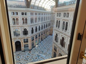 A grand interior with ornate architecture, a central open space, and a patterned floor. - Hotel Art Resort Galleria Umberto (Naples)