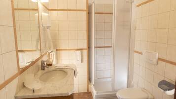 A bathroom with a sink, toilet, and shower.