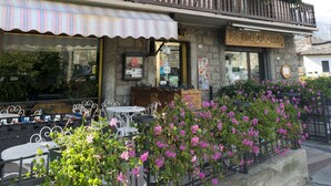 A hotel with multiple balconies, outdoor seating, and a sign reading "HOTEL DU CHATEAU". - Chateau (Saint-Pierre)