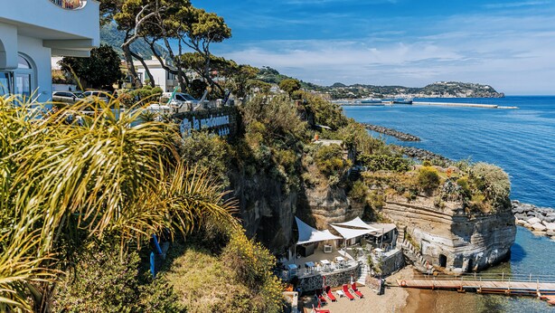 Un hôtel en bord de mer doté d’une terrasse offrant une vue sur l’océan, une falaise rocheuse et le littoral.