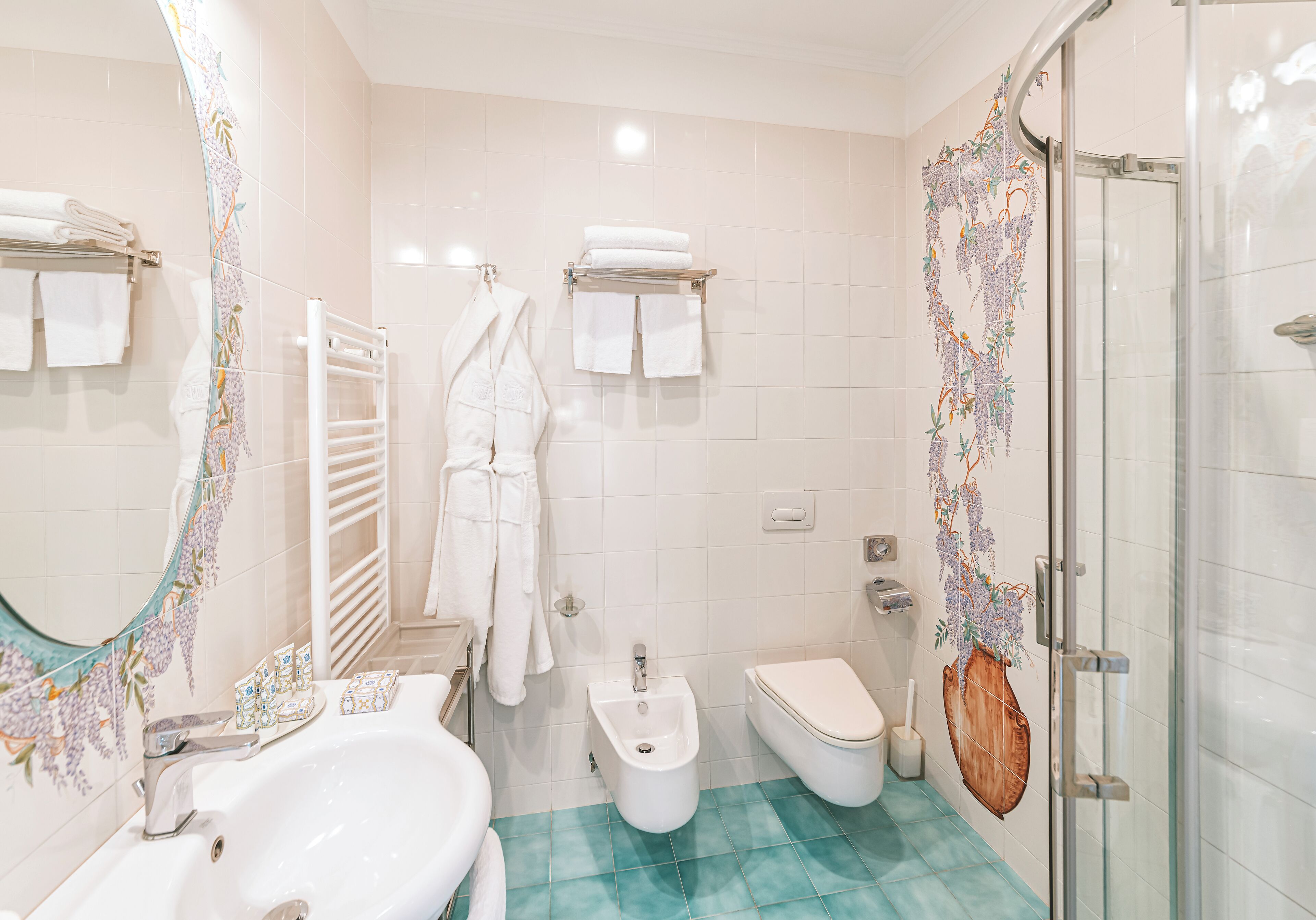 Un baño con lavamanos, bidé, inodoro y cabina de ducha de vidrio.