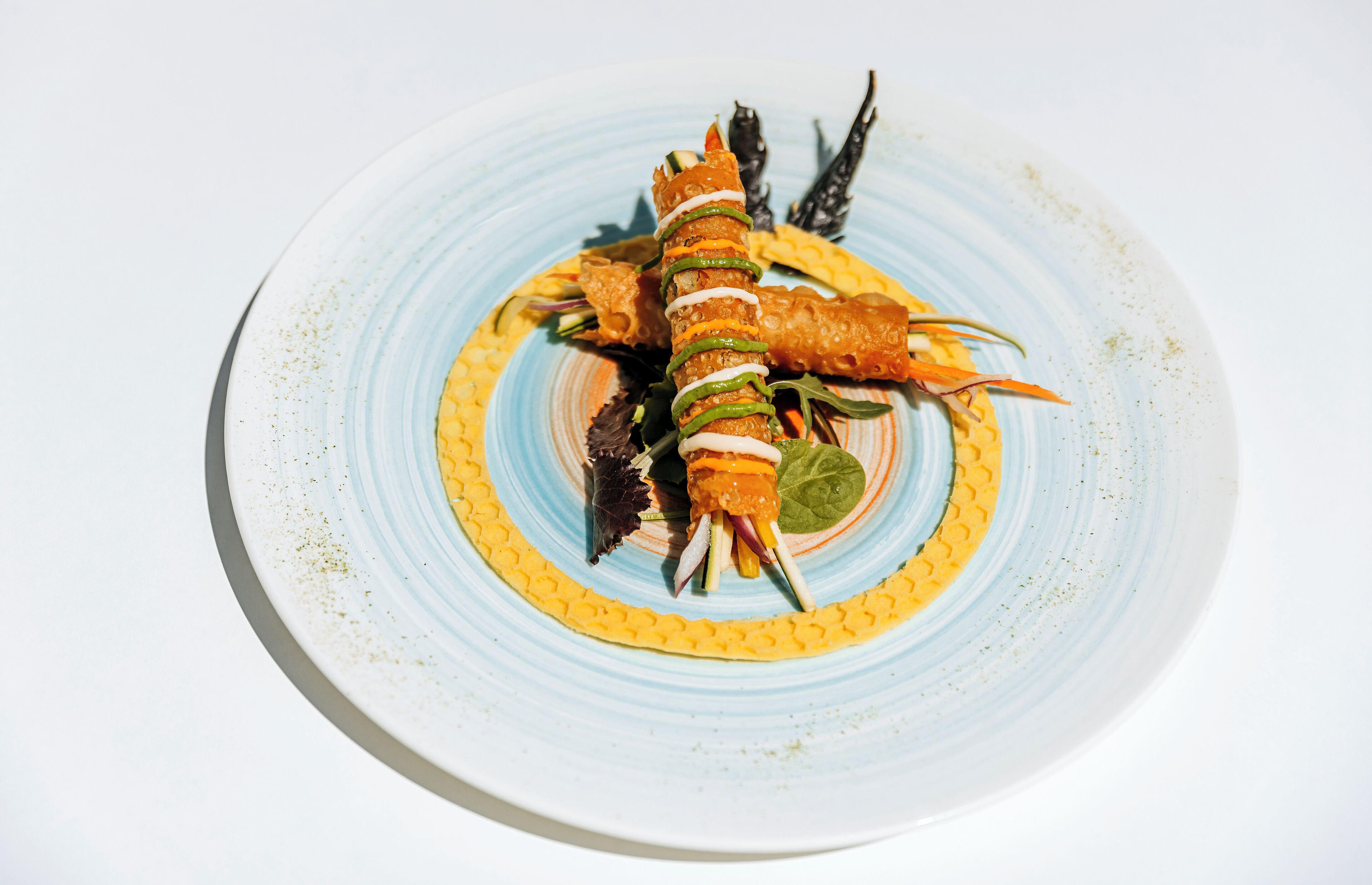 A plate with a seafood dish, possibly lobster, garnished with herbs and a slice of lemon.