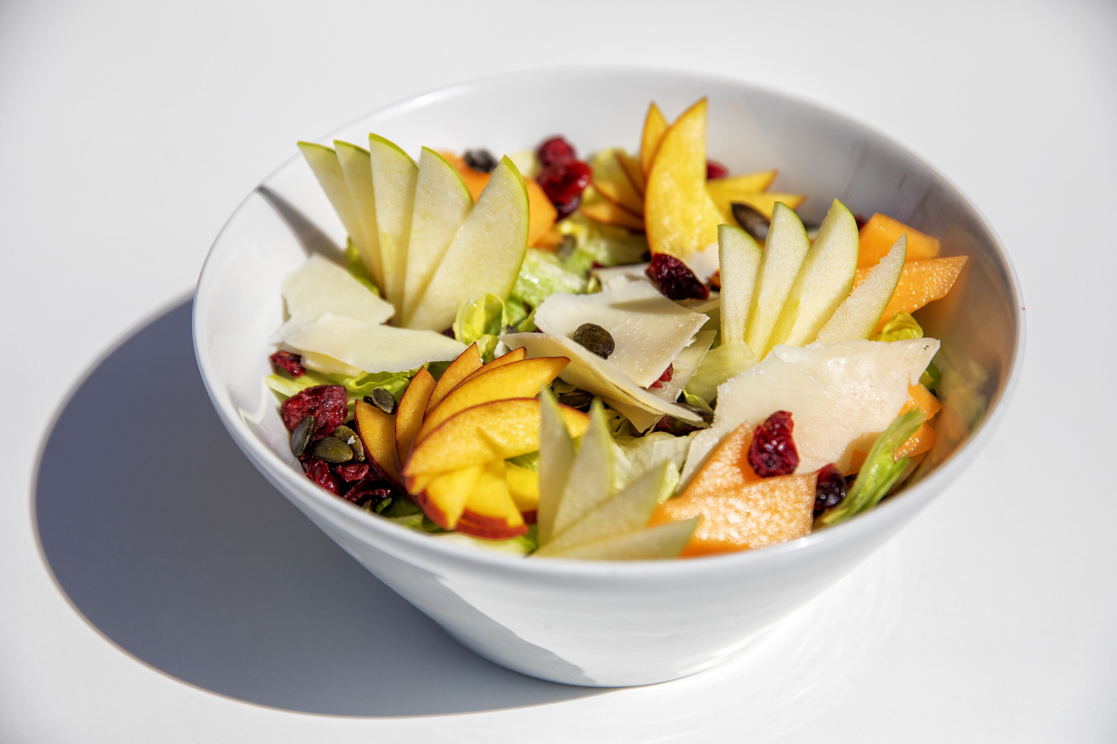 Eine Schüssel mit Obstsalat, der verschiedene Früchte und Nüsse enthält.