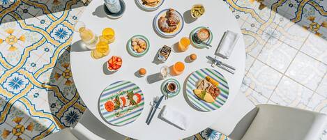 Una mesa redonda con platos de comida, una taza de café y un vaso de jugo de naranja.