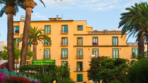 A multi-story building with a yellow facade, balconies, and a sign for a restaurant. - Hotel Eden (Sorrento)