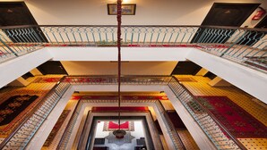 A multi-level interior with ornate railings, patterned carpets, and a central decorative element. - Hotel Le Caspien (Marrakech)