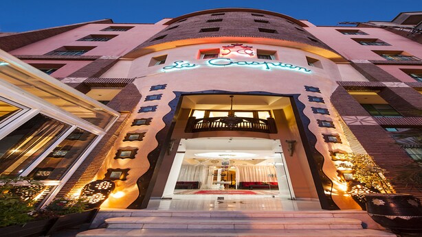 A hotel entrance with a modern design, featuring a prominent sign and a well-lit facade. - Hotel Le Caspien (Marrakech)
