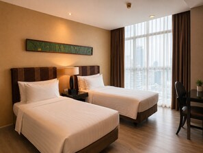 A hotel room with two beds, a desk, a chair, and a large window with a city view.
