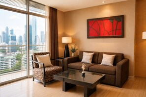 Une chambre d’hôtel moderne avec vue sur la ville, comprenant un canapé, un fauteuil, une table et une lampe.
