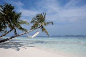 On the beach, white sand, beach towels, windsurfing