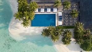 An aerial view of a resort with a swimming pool surrounded by palm trees and sun loungers. - Vilamendhoo Maldives Resort Island (Vilamendhoo Island)