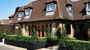 A two-story house with a pitched roof, multiple windows, and a brick exterior. - The Boleyn Hotel (Staines)
