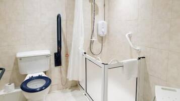 A modern bathroom with a toilet, bidet, shower, and a wheelchair-accessible sink.
