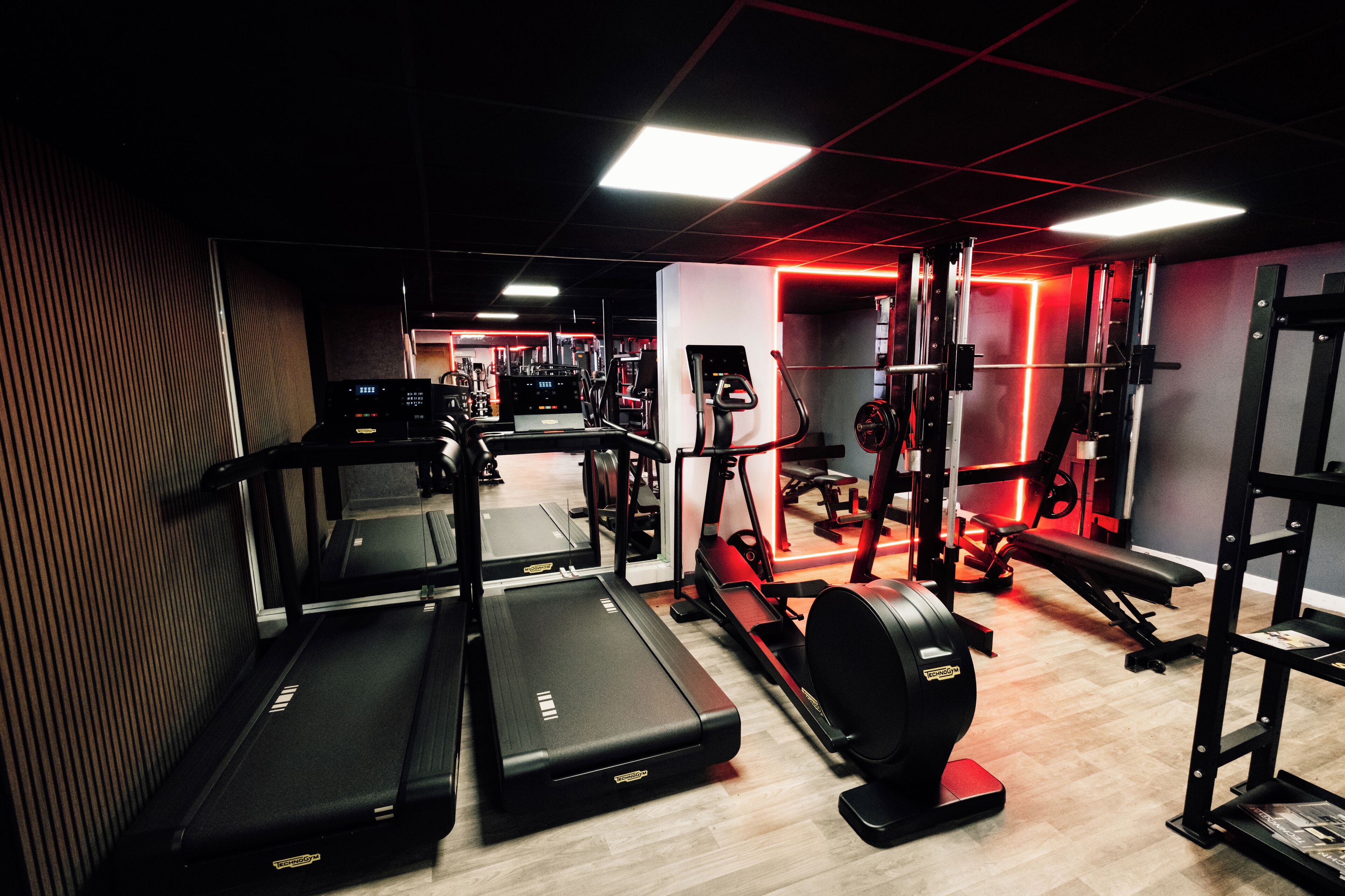 A gym with treadmills, a stationary bike, and weightlifting equipment.