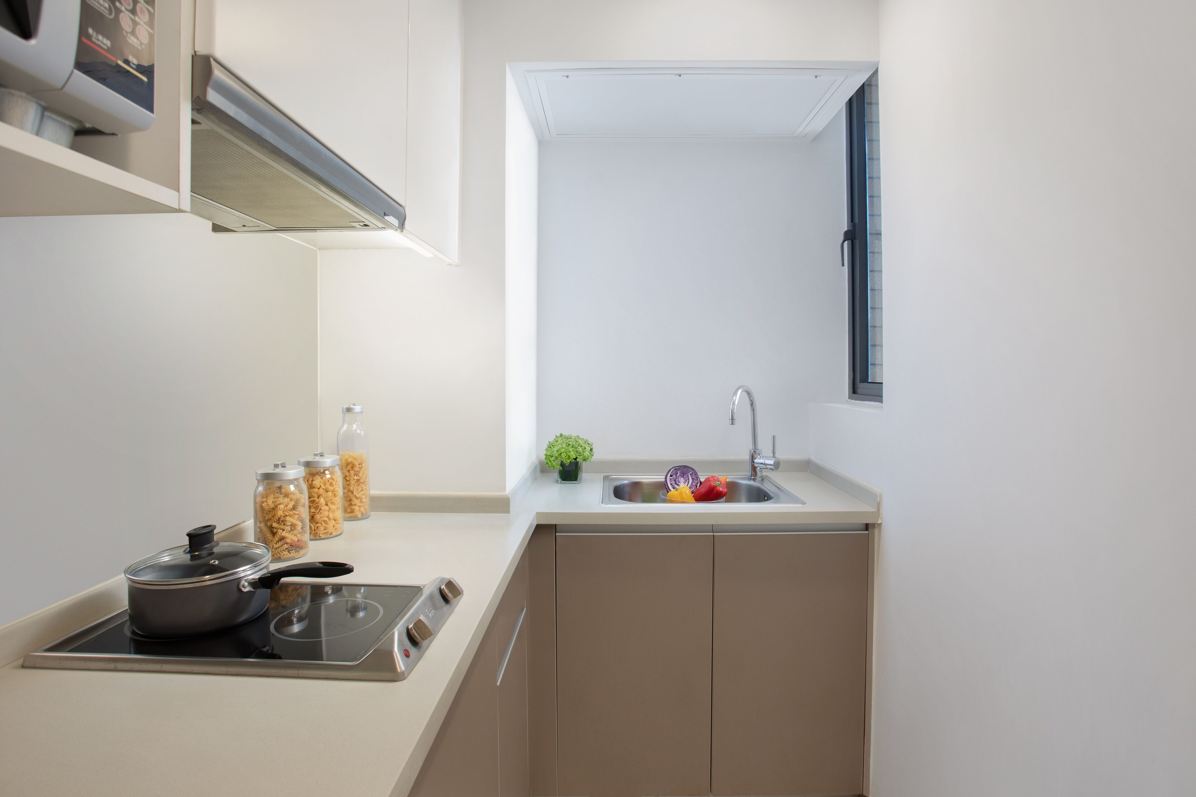 A compact kitchen with a built-in stove, a sink, and storage cabinets.